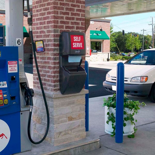 A Commercial Zone Vue-T-Ful Isle charcoal gray windshield washing service center with a gas pump and paper towel dispenser.