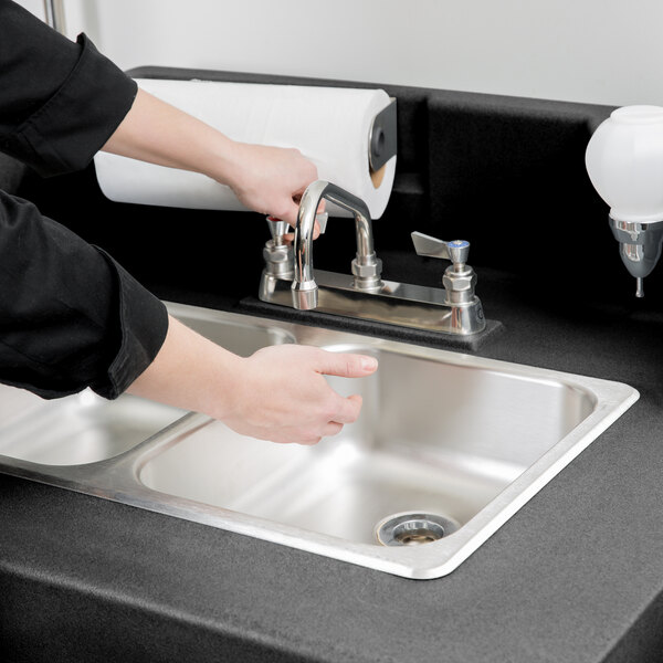 a hand pointing at a sink