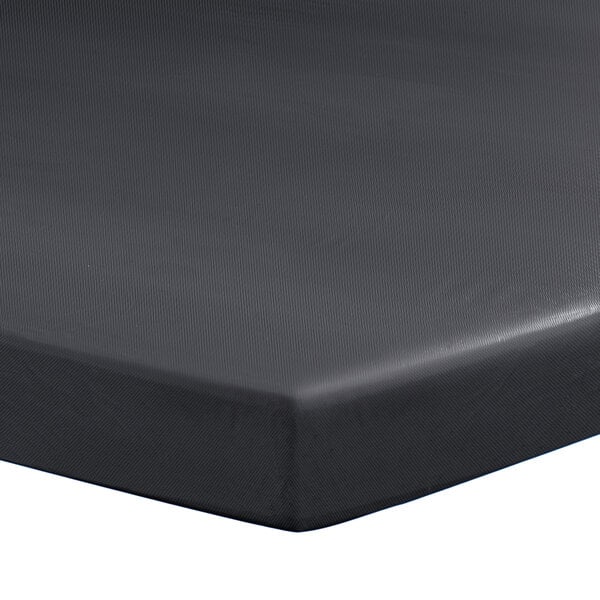 A black Creative Converting rectangular plastic tablecloth with elastic on a table.