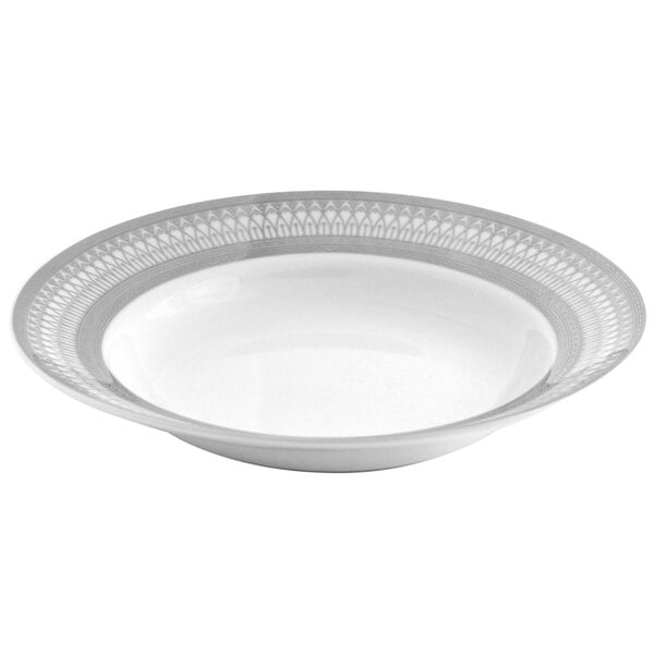 A white porcelain bowl with a silver wide rim and a pattern on it.