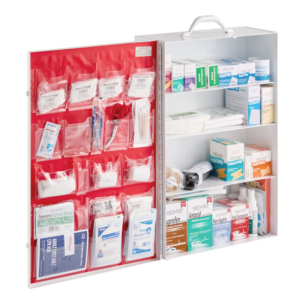 An open first aid cabinet with multiple shelves and clear pockets, containing various medical supplies such as bandages, medications, scissors, and first aid essentials.