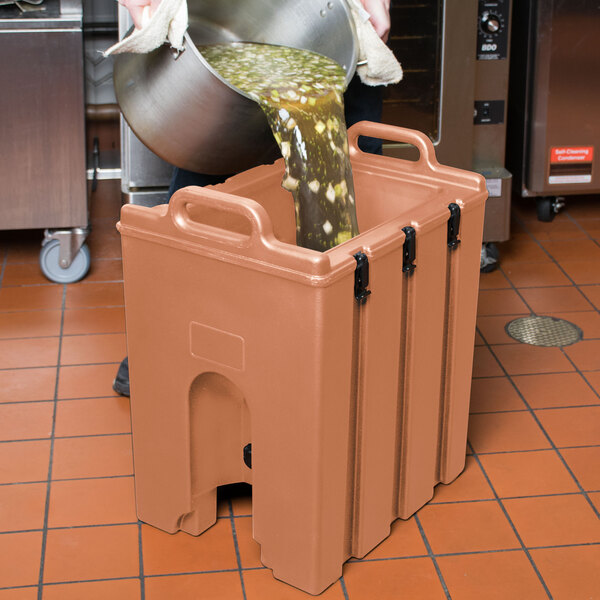 A man pouring liquid into a Cambro insulated container.