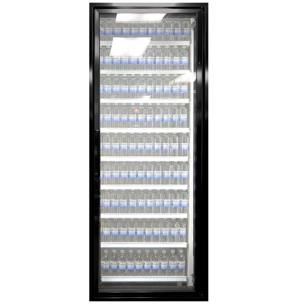 A Styleline walk-in cooler merchandiser door with glass shelves full of water bottles.