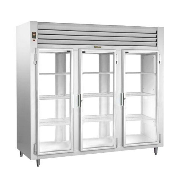 A white Traulsen three section glass door reach-in refrigerator with open glass doors.