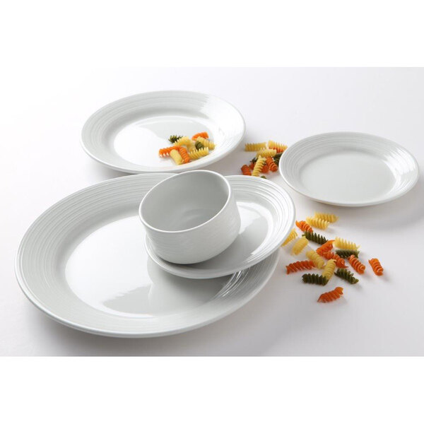 A close-up of a Tuxton Pacifica bright white embossed plate with a bowl of pasta on it.