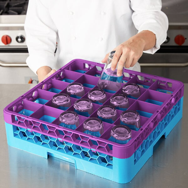 A woman using a Carlisle lavender and blue glass rack to wash glasses.