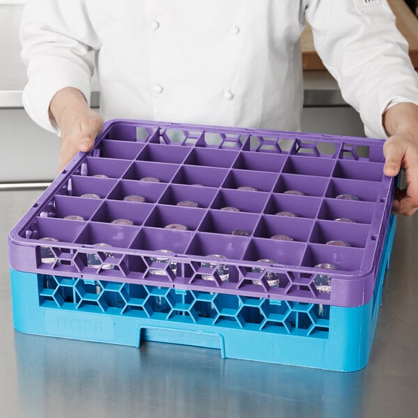 A person holding a purple Carlisle plastic glass rack extender.