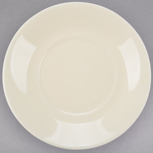 A white porcelain cup and saucer with a circular edge.