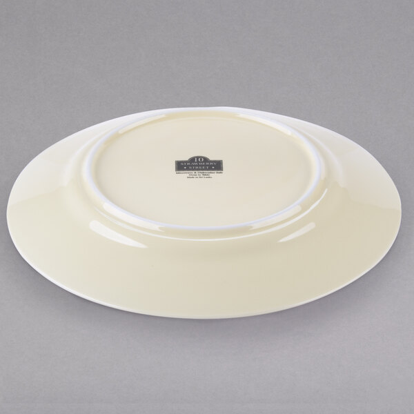 A white porcelain luncheon plate with a black rim.