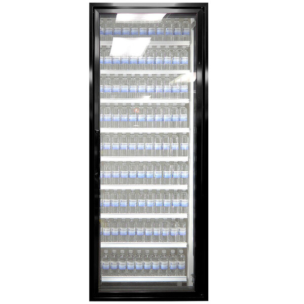 A black Styleline walk-in freezer door with glass shelving holding blue bottles of water.