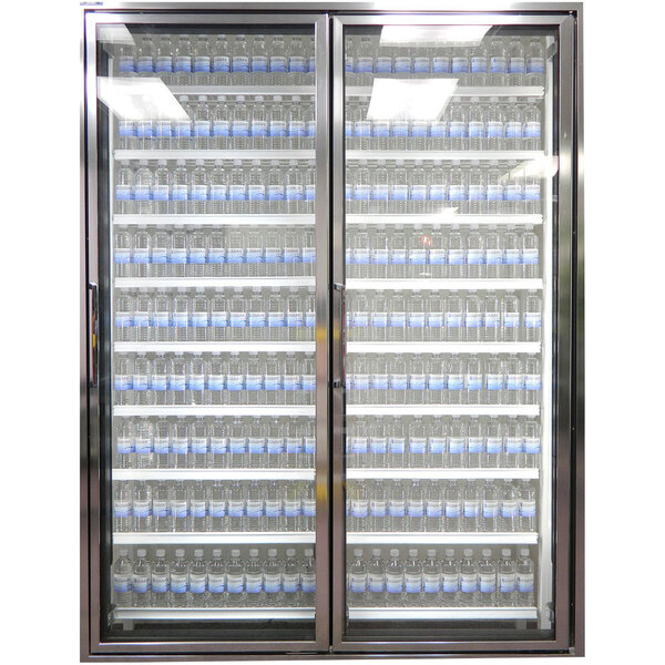 A Styleline walk-in cooler glass door with shelving holding bottles of water.
