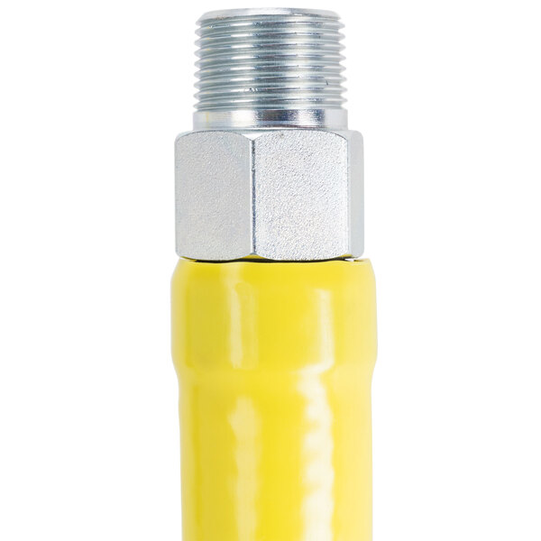 A yellow T&S gas appliance connector with silver metal end fittings.
