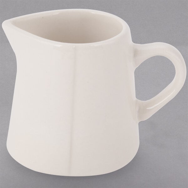A Libbey Farmhouse ivory porcelain creamer with a handle.