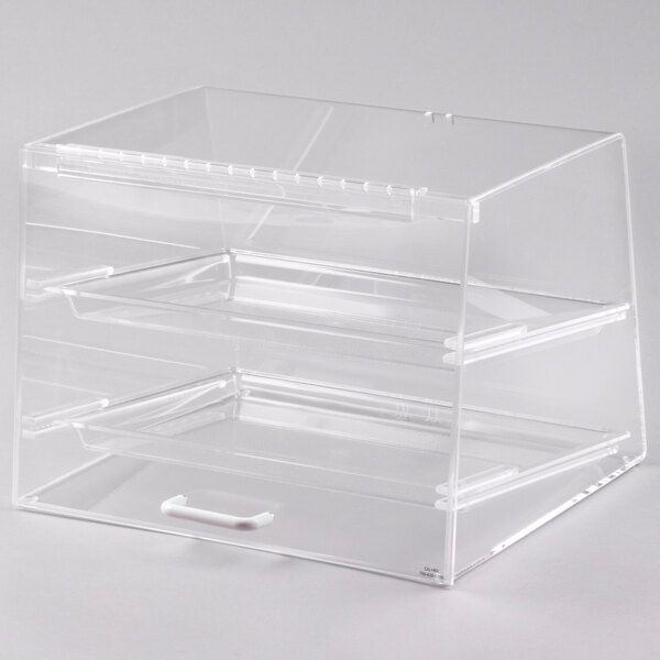 A clear plastic container with two shelves on a counter in a bakery display.