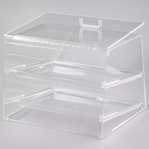 A clear plastic two tier display case with a rear door on a counter in a bakery.