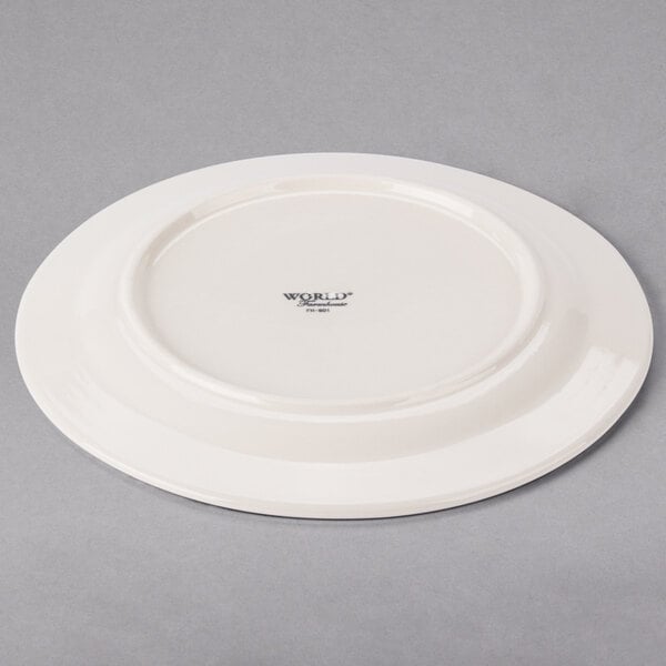 A Libbey medium rim porcelain plate in ivory with a small black logo on the rim.
