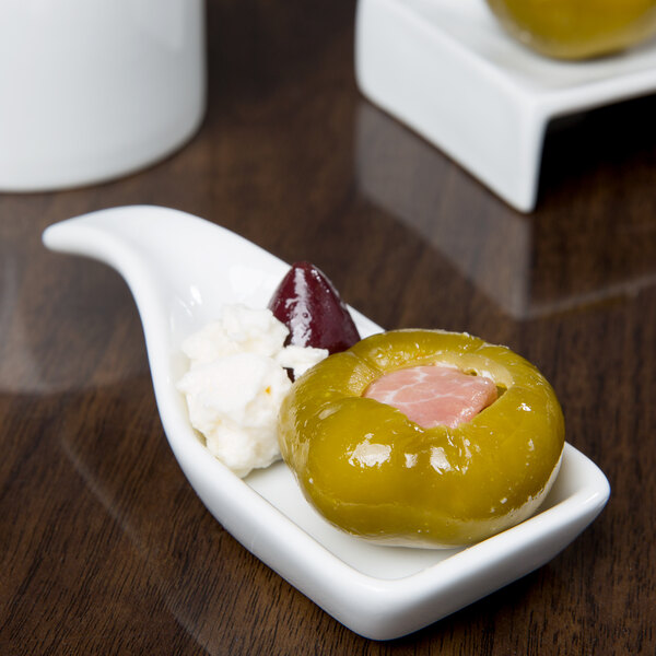 A Libbey porcelain spoon with food on it.