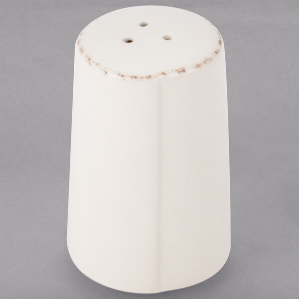 A Libbey ivory porcelain pepper shaker on a gray surface.