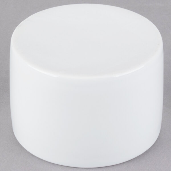 A white cylinder on a gray surface with a white Libbey Chef's Selection bowl inside.