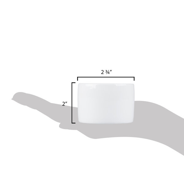 A hand holding a Libbey ultra bright white porcelain canne bowl with a black border.