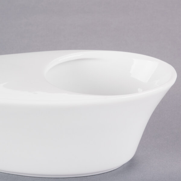 A Libbey white porcelain bar snack dispenser bowl with a hole in the bottom on a white background.