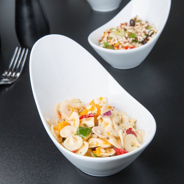 A table with a bowl of pasta and a bowl of rice with vegetables and a fork.