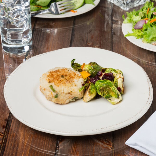 A Libbey Farmhouse ivory porcelain plate with food on a table.