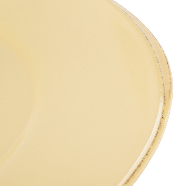 A close-up of a Libbey Farmhouse yellow porcelain plate with a wide rim.
