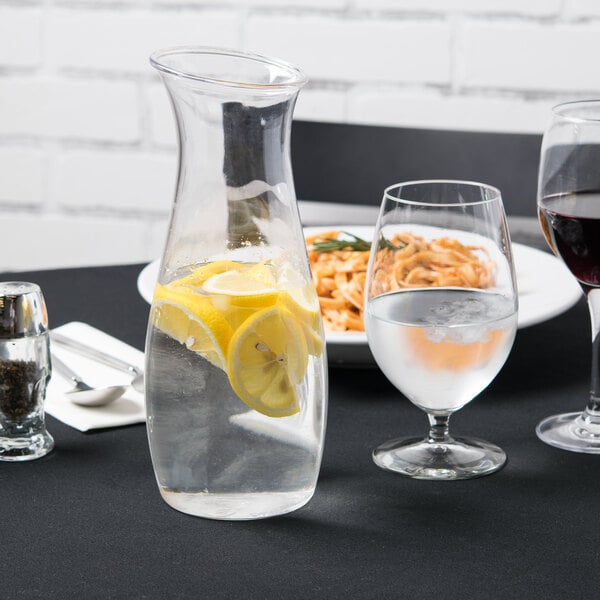 Glass carafe of water with lemon with elegant water goblet