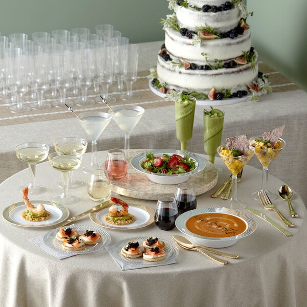 A table with Visions 2-piece martini cups filled with food, a bowl of salad with strawberries and pecans, and a glass of wine.