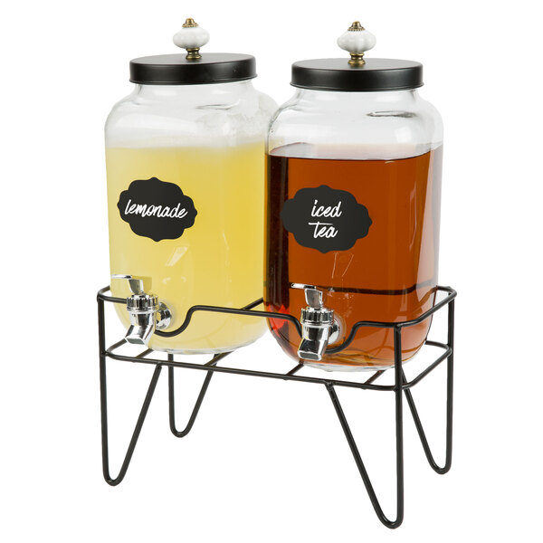 A Stylesetter glass beverage dispenser with metal stand holding two drink dispensers.