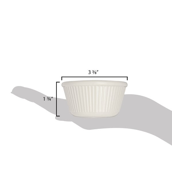 A hand holding a white Carlisle fluted ramekin.