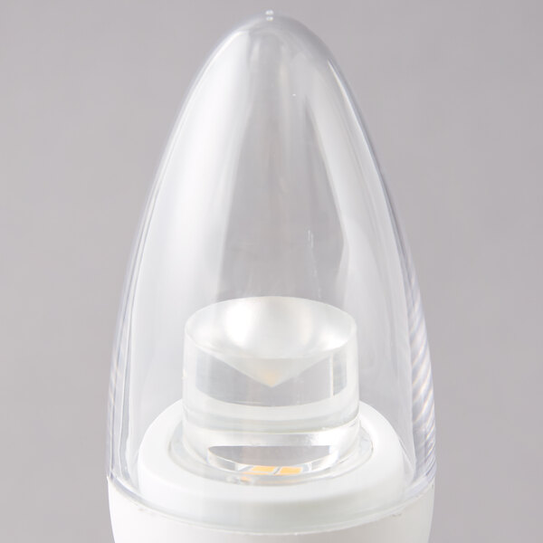 A close up of a Satco clear LED light bulb with a candelabra base and warm white light.