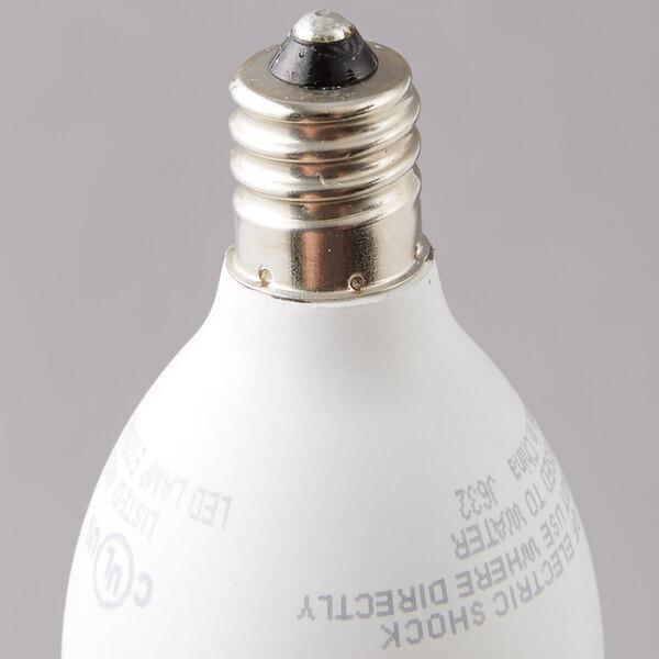 A close-up of a Satco clear warm white LED light bulb with a candelabra base.