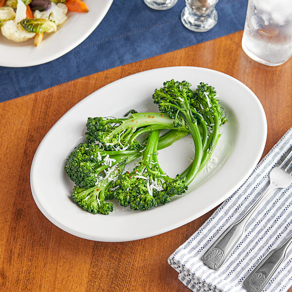 A close-up of a platter of broccoli on a table.