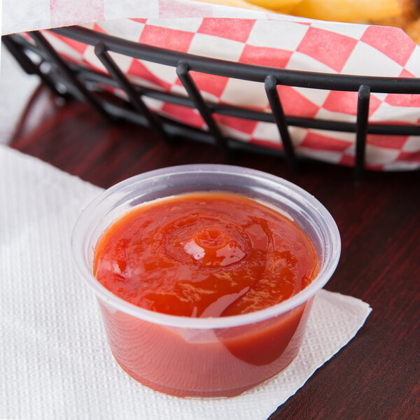 Small plastic portion cup holding ketchup