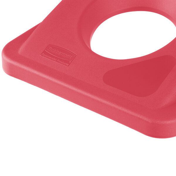 A close-up of a red Rubbermaid Slim Jim recycling container lid.