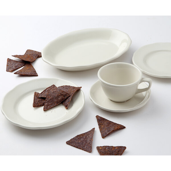 A Tuxton ivory eggshell scalloped edge china plate with a spoon