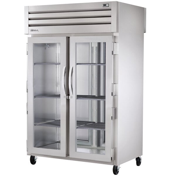 A True Spec Series pass-through heated holding cabinet with glass front and solid back doors.