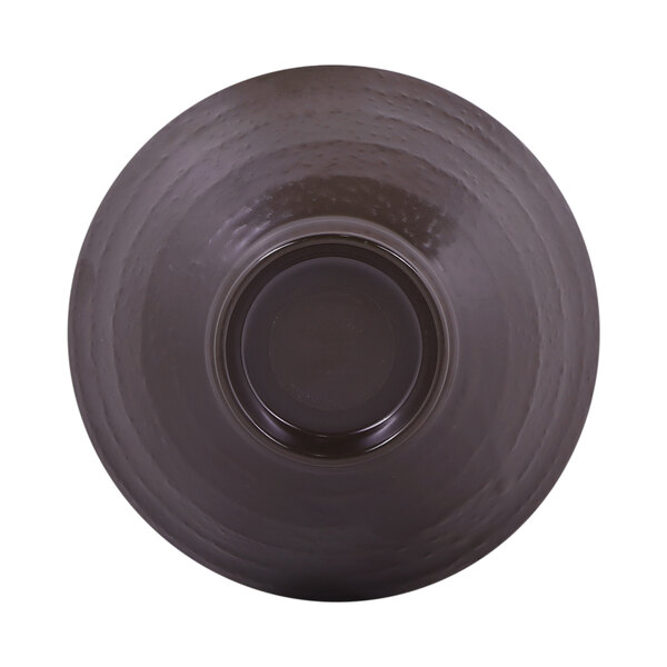 An antique white bowl with a chocolate brown interior and black rim.