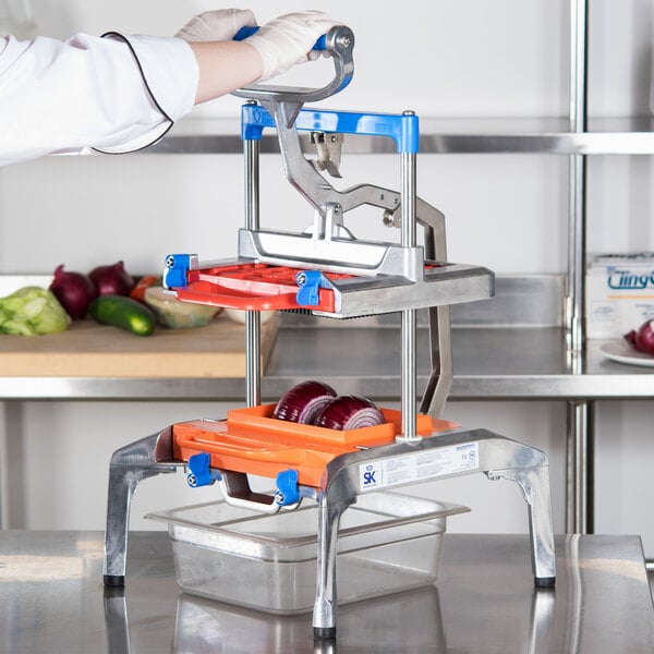 A person wearing white gloves uses a Prince Castle Saber King 1/4" Dicer to cut up an apple.