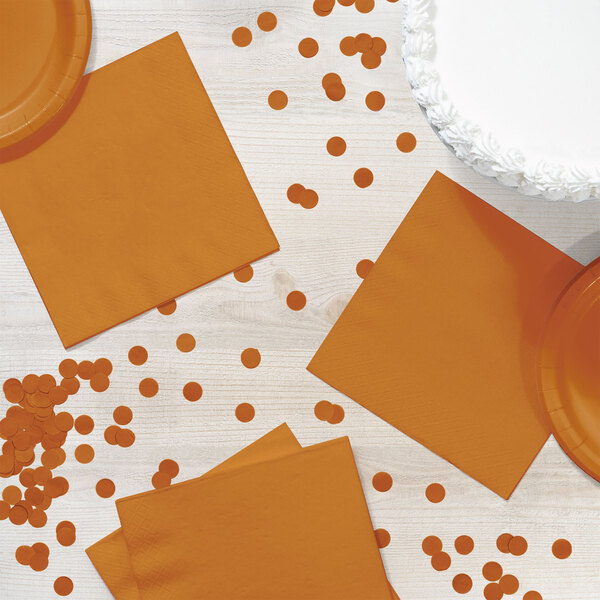 A table with orange plates and Creative Converting Pumpkin Spice orange luncheon napkins.