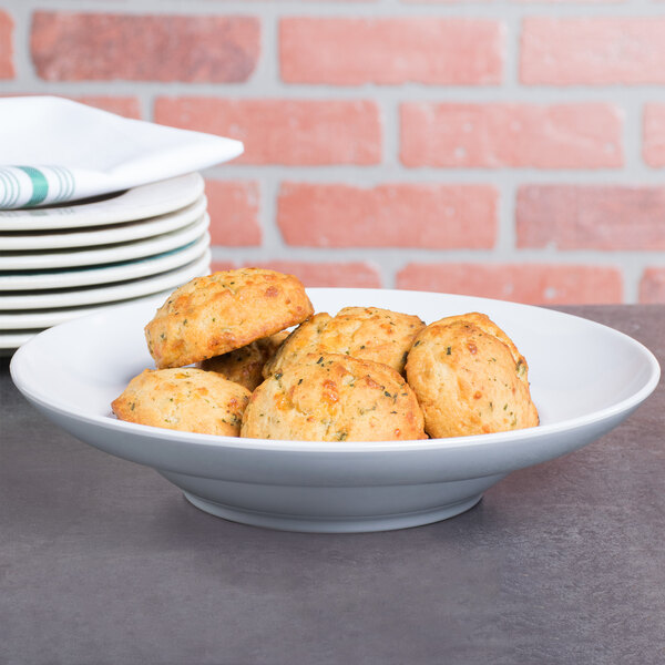 Elite Global Solutions D10 The Patriarch white melamine bowl filled with food on a table in a hotel buffet.