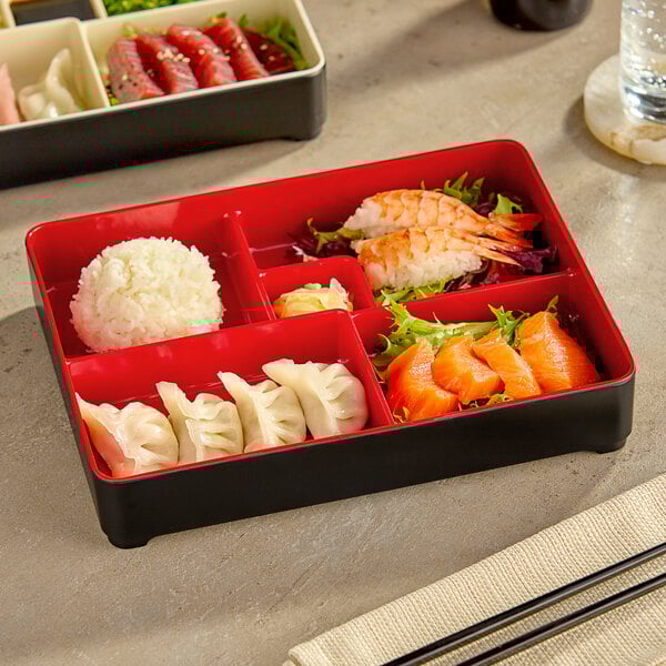 A black and red Bento Box tray with food in it.