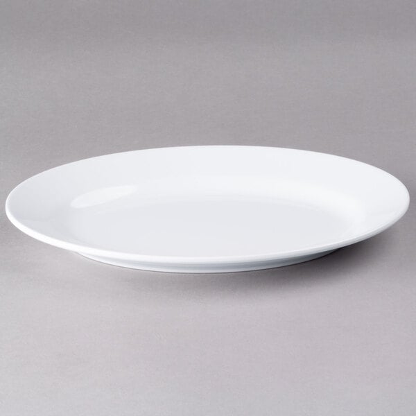 An Elite Global Solutions white oval melamine plate on a gray surface.