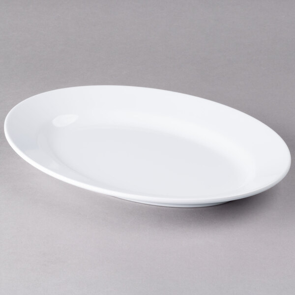 An Elite Global Solutions white oval melamine plate on a gray surface.