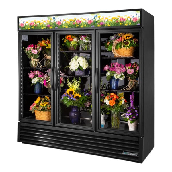 A black True refrigerated floral case filled with flowers.