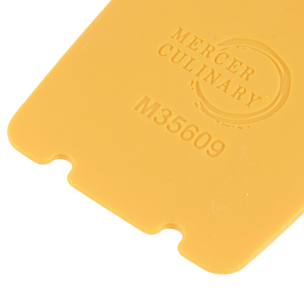 A yellow silicone wedge with a horseshoe arch from Mercer Culinary.
