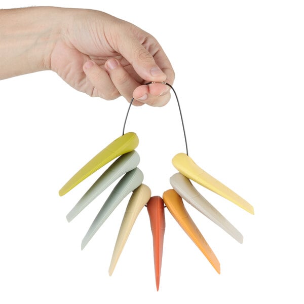 A hand holding a set of white and green silicone plating objects.