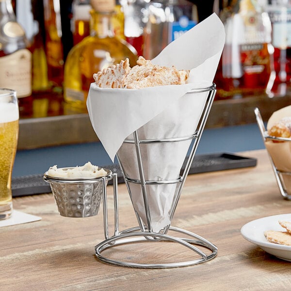 A Clipper Mill stainless steel wire cone basket with a white paper in a round metal container.